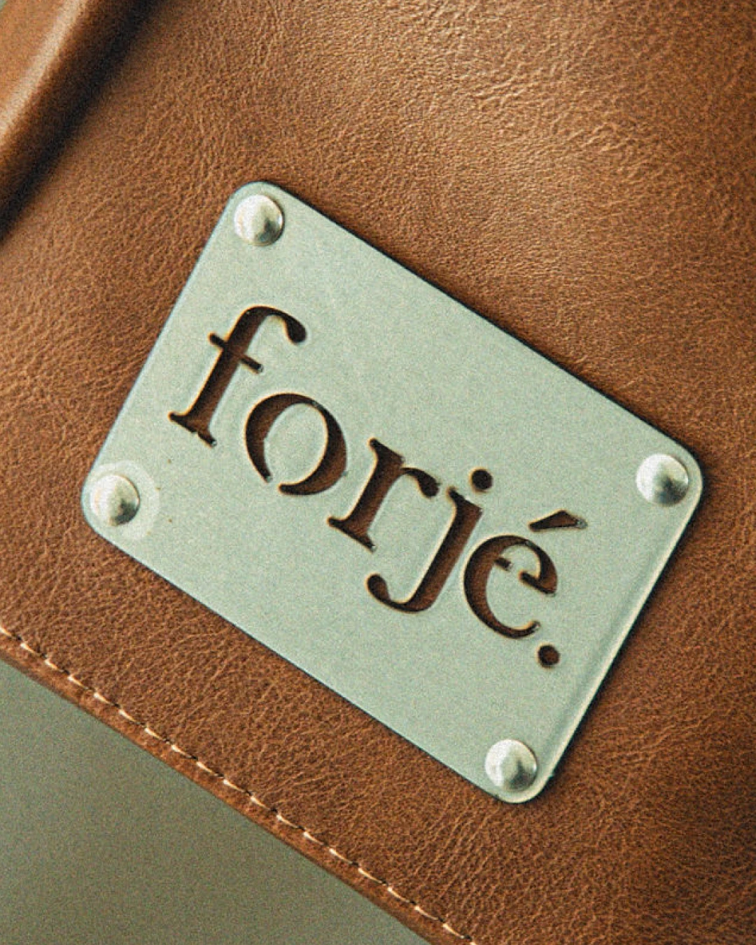 Forjé — placa metálica cosida sobre cuero.