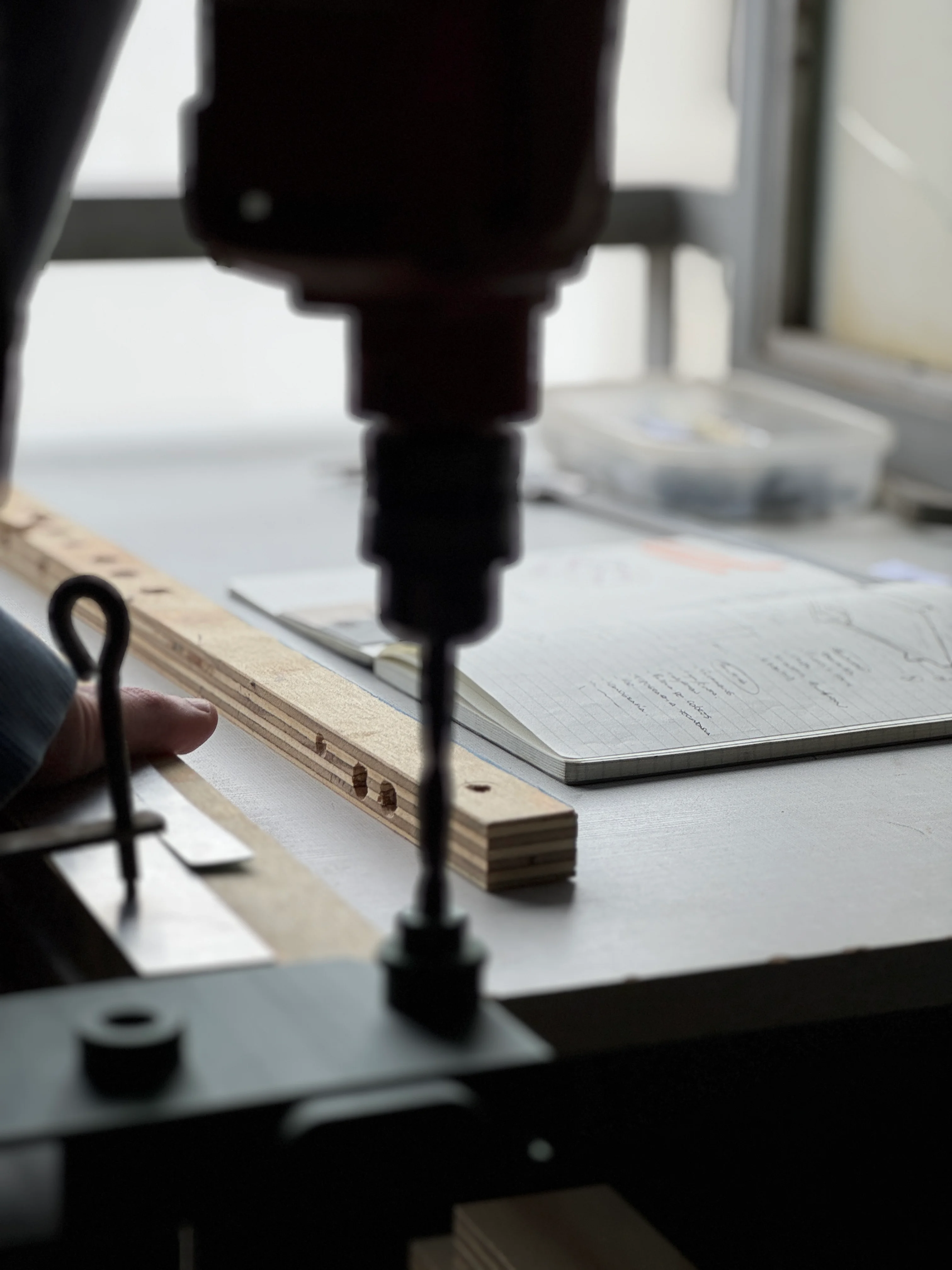 Una agujereadora de banco perfora una matriz de madera en el taller.